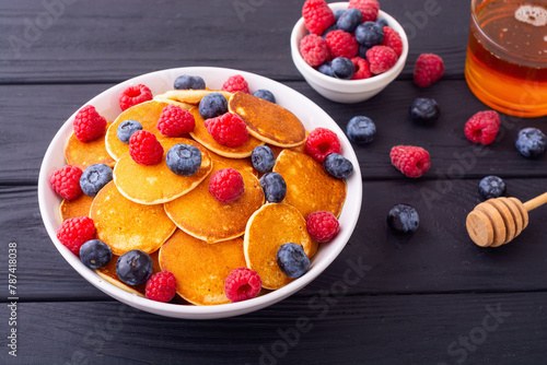 Mini pancakes with berries . Delicious breakfast