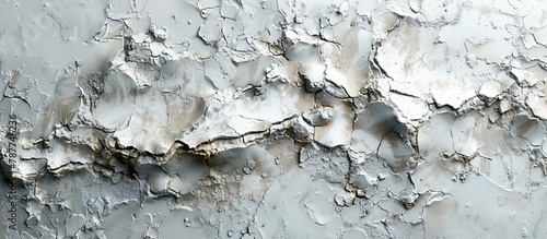 Close up view of a wall with white paint peeling off, revealing the texture and layers underneath in a deteriorating condition
