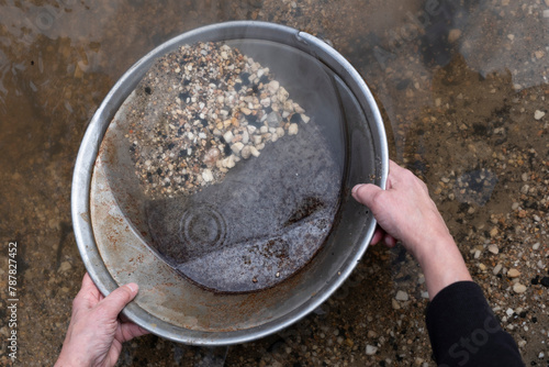 Panning for gold with a prospector's pan at Sovereign Hill tourist attraction in Ballarat, Victoria Australia