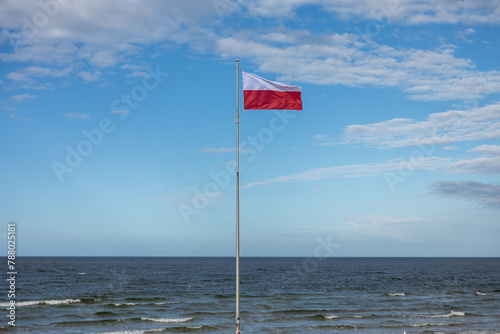 Polskie barwy narodowe, Polska flaga na tle nieba nad morzem. Bałtyk Kołobrzeg Zachodniopomorskie 