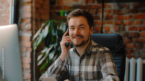 "Computer expert talking to their customer on the phone in an office"