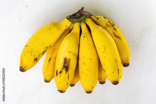 A bunch of fresh ripe yellow bananas on wooden textured white background. Bananas are healthy fruit.