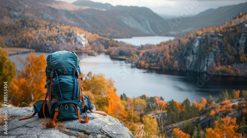 beautiful traveler backpack on a stone with a lake and mountains in the background in autumn in high resolution and high quality