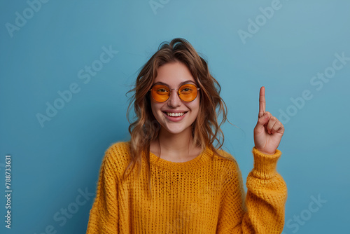 Portrait of young funny woman brown curls direct finger empty space shocked see secrets isolated on blue color background