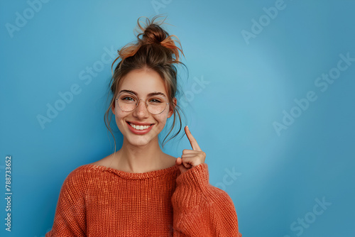 Portrait of young funny woman brown curls direct finger empty space shocked see secrets isolated on blue color background