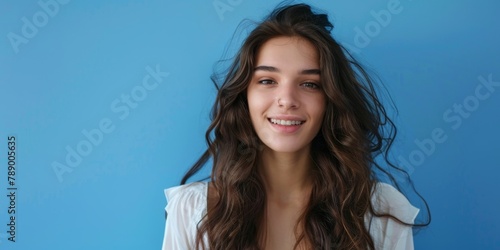 Place for text. Portrait of a beautiful young brunette girl with nose piercing on a blue background. Banner for advertising cosmetics, dentistry, piercing, hairdressing services, discounts
