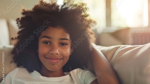Close up beautiful African teenager girl sitting on sofa at home staring into distance feel happy having wide toothy charming smile and natural afro curly hairs posing indoors Generati : Generative AI