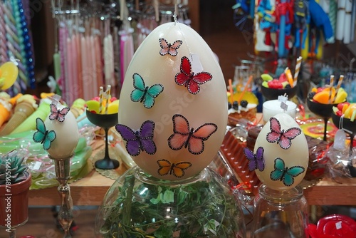 Egg shaped Easter decoration candle, decorated with colorful butterflies, in a shop window, in Athens, Greece