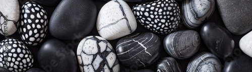 A close up of a pile of black and white rocks., banner