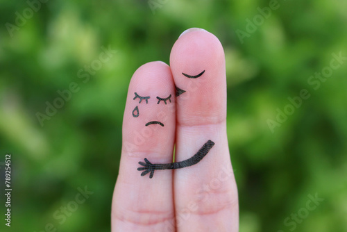 Finger art of displeased couple. Woman cries, man reassures her. He kisses and hugs her.