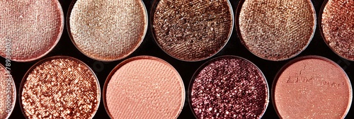 A close-up of a circular rose gold toned eyeshadow palette