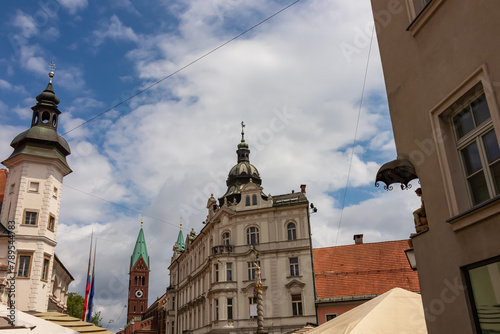 Vibrant atmosphere of street cafes on Grajski Trg or Castle Square. View of Maribor Castle and Regional Museum offering rich history. Grandeur of St. Florian Column, symbol of Maribors resilience.
