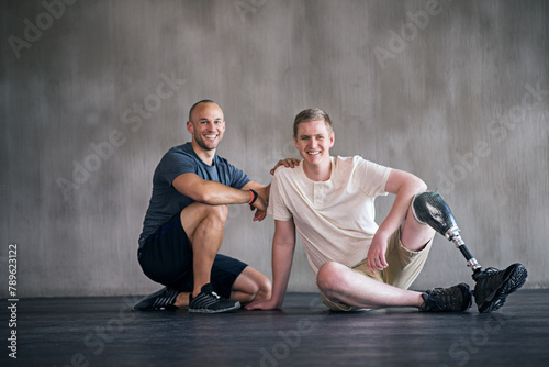 Physiotherapist, person with a disability and prosthetic leg and smile in physiotherapy, studio and gym. Male people, trainer and amputee for wellness, fitness and exercise in sports center