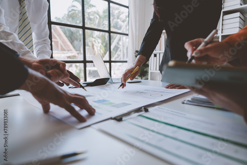 Financial analyst analyzes business finance reports on laptop and graph documents during corporate meeting discussions showing successful teamwork, business meeting ideas, marketing.