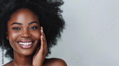 beautiful black woman with radiant skin smiling while touching her face on a white background, beauty and spa advertising banner or poster, copy space,advertising beauty and spa services