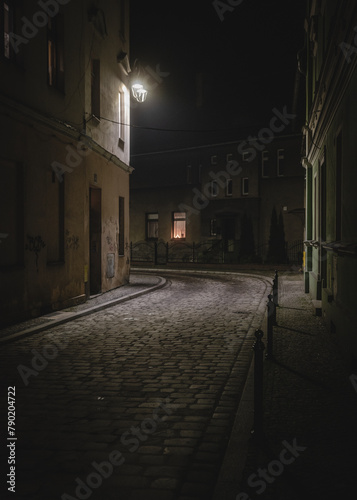 ciemna brukowana uliczka w nocy w mieście