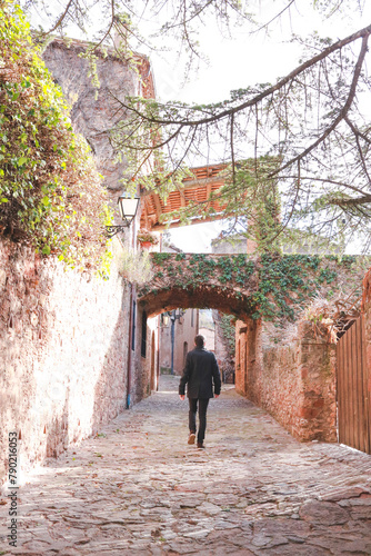 Young man walks along a picturesque street in a beautiful medieval town