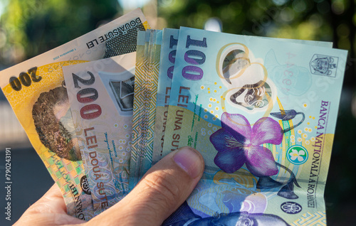 Romanian money hand. Romanian LEI currency, close up. Romanian banknotes of 50, 100 and 200 lei in hand. Making payments, inflation and economic situation concept