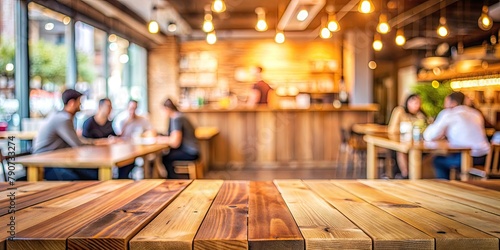 Empty wood table top with blurred background of people sitting in a coffee shop, fast food restaurant or pub for product display montage. Concept for advertising design, layout presentation, banner