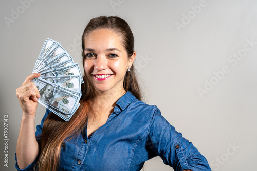Mujer feliz y sonriente sosteniendo mucho dinero en forma de abanico