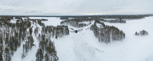 Aerial view over taiga landscape with snow covered boreal forest and frozen lakes in northeast Finland 