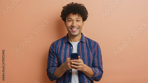 Smiling man recommending a vibrant mobile app on a peach background, photo