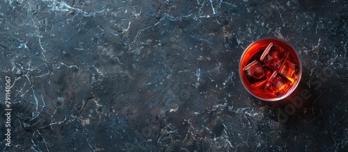 Negroni cocktail displayed on a dark stone table. Top view with room for your own text.