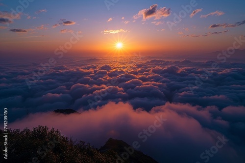 the sun is rising over clouds over the mountain