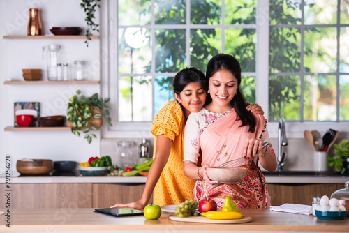 Indian mother daughter cooking in kitchen