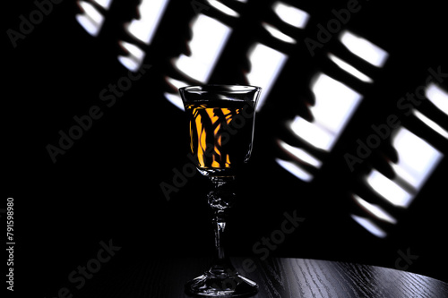 Jeden kryształowy kieliszek z jasnym drinkiem stoi na barze, nocna impreza