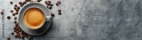 Top view of a cup of coffee on a gray stone table with scattered coffee beans.