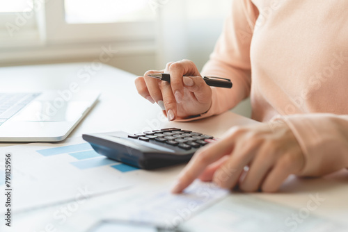 Deduction planning, debt asian young woman hand using calculator to calculating money balance from bill and income, cost budget expenses for pay money form personal individual on table at home.