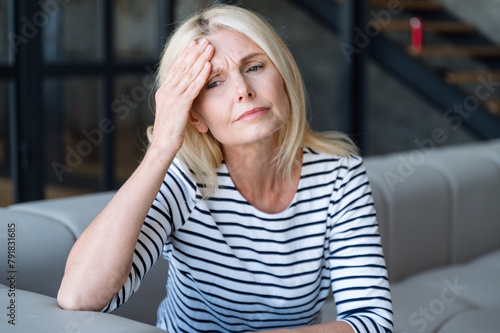 Upset middle aged woman feeling bad and has headache