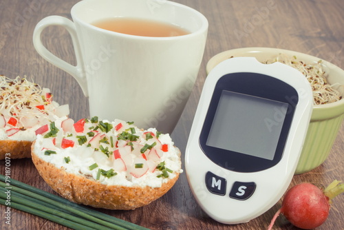 Glucometer for checking sugar level, freshly breakfast with tea. Healthy nutrition during diabetes