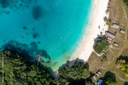Drone view of sandy beach and green shore near turquoise sea. Tourist settlement. Sanma, Vanuatu..