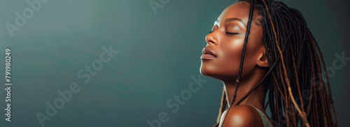 A beautiful African American woman with dreadlocks in the studio on an isolated gray banner background.