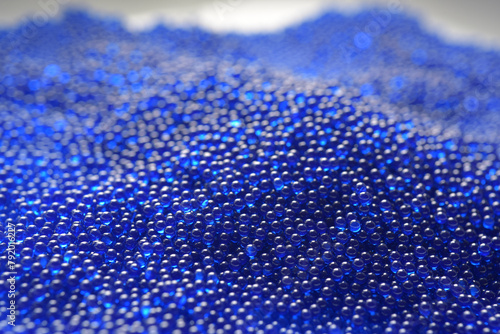 Abstract background in soft selective focus of the blue spherical shape water gel balls, beads or blasters