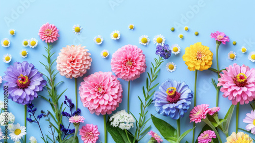 A vivid arrangement of various garden flowers, including zinnias and daisies, on a light blue canvas.