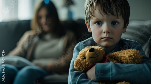 A child clutching a teddy bear, with audible arguing in the background