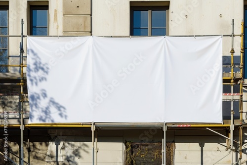Sunny day with white banner on construction site fence for ads
