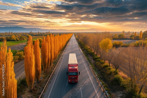 Trucks on the road surrounded by autumn countryside at sunset