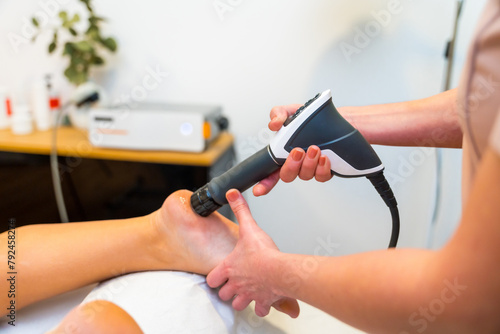 Patient receiving a shockwave therapy massage on foot