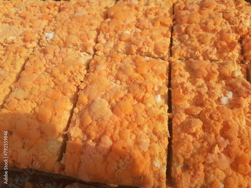 Raw oncom on a wooden shelf at a traditional roadside market trader.Oncom is mushroom-infused tempeh made from peanut cake and tofu dregs.Oncom is a fermented food with several types of mold.