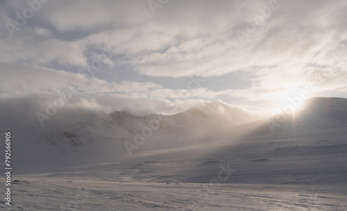 A low sunbeam shines through a col in the Sylarna mountains on a ski tour in Sweden