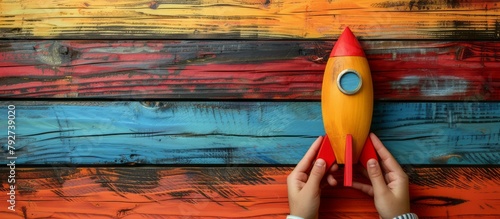 Children Launching a Red Rocket on Colorful Wooden Background