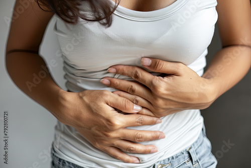 A woman experiencing abdominal discomfort, clutching her stomach