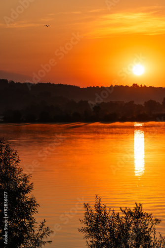 Romantyczny wschód słońca nad jeziorem w letni dzień