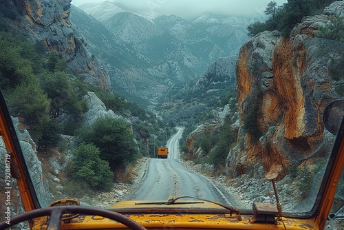 A trucker's view from the cab as they navigate a winding mountain road, with steep cliffs and hairpin turns