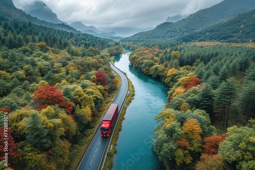 An aerial view of a convoy of semi-trucks crossing a picturesque bridge spanning a wide river