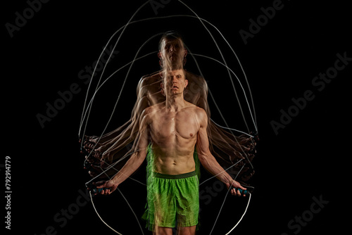 Essence of sport and athleticism. Muscular man in motion, training, doping cardio, jumping rope against black background with stroboscope effect. Concept of sport, active and healthy lifestyle